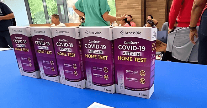 Photo of 5 at-home COVID tests lined up on a table.