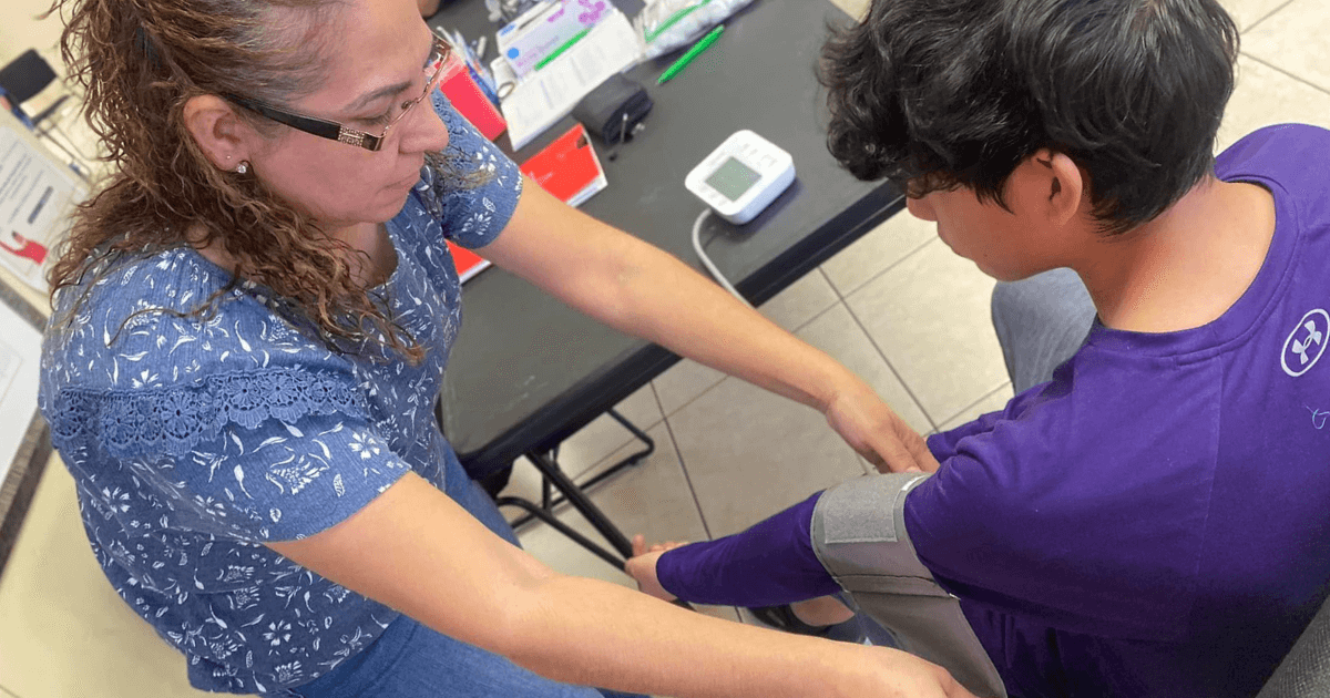 Volunteer providing a patient with a blood pressure test.